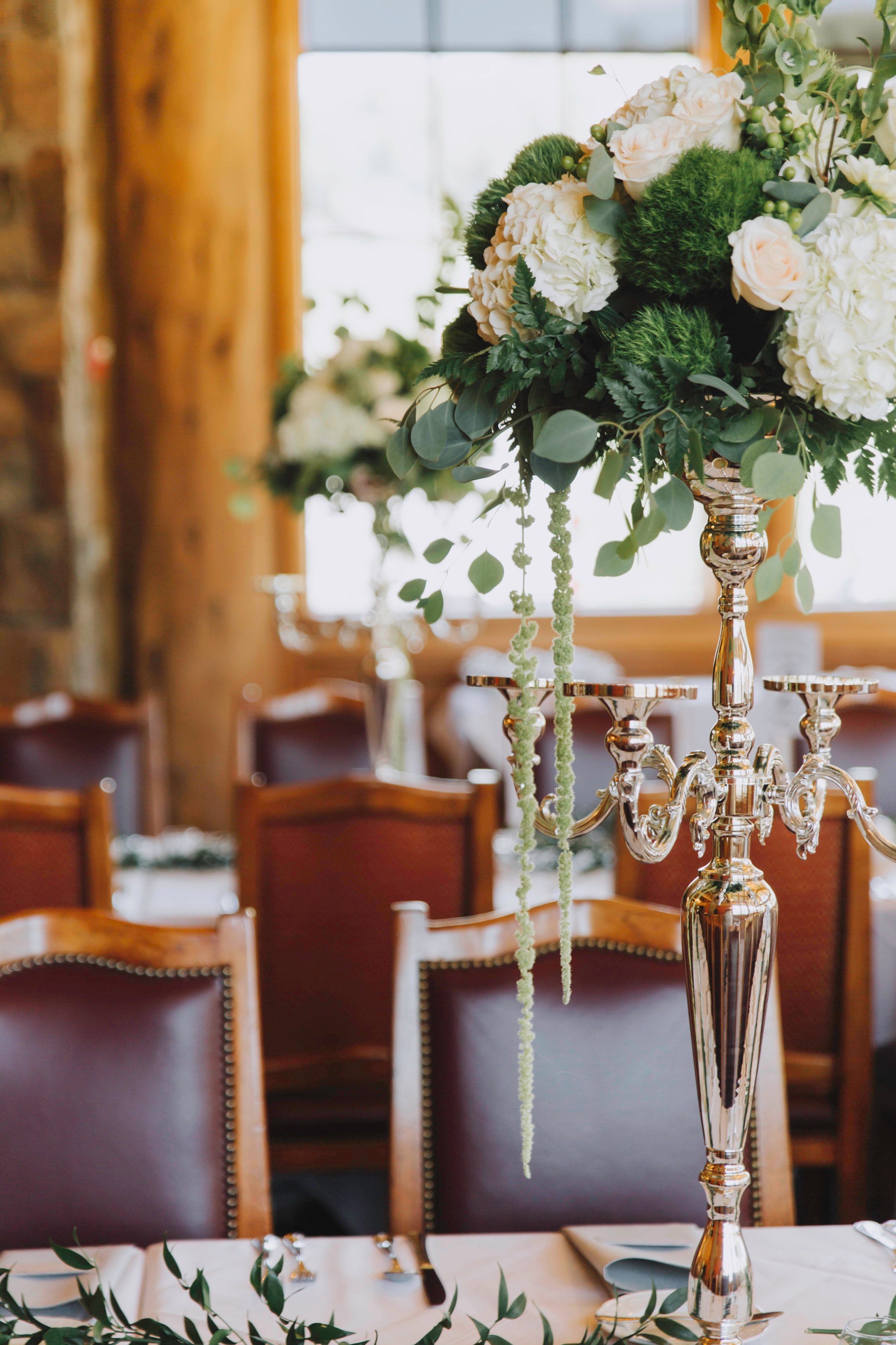 Vibrant floral arrangements on bar counter against brick wall