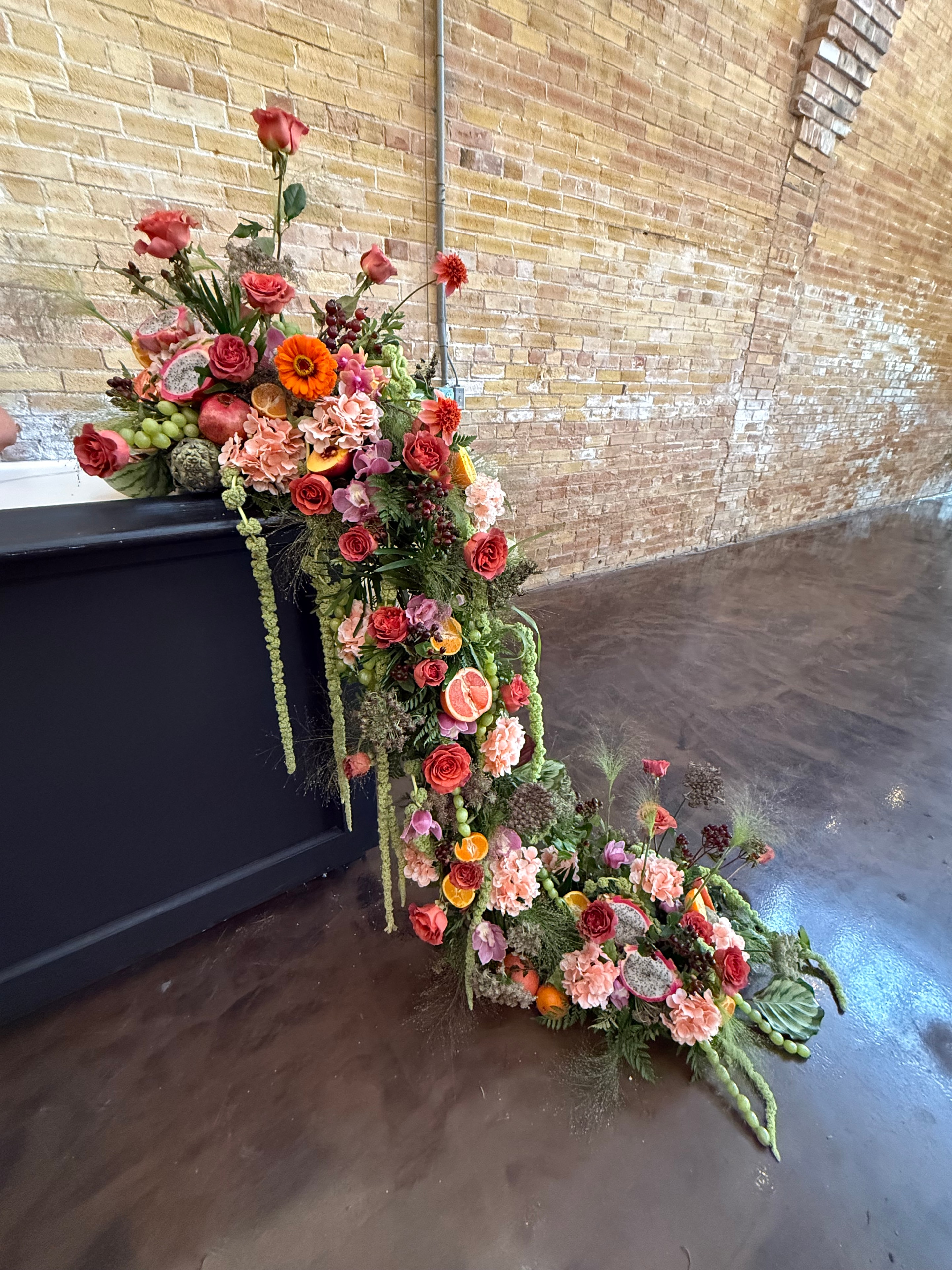 Bar garland with coral roses, citrus, and tropical blooms