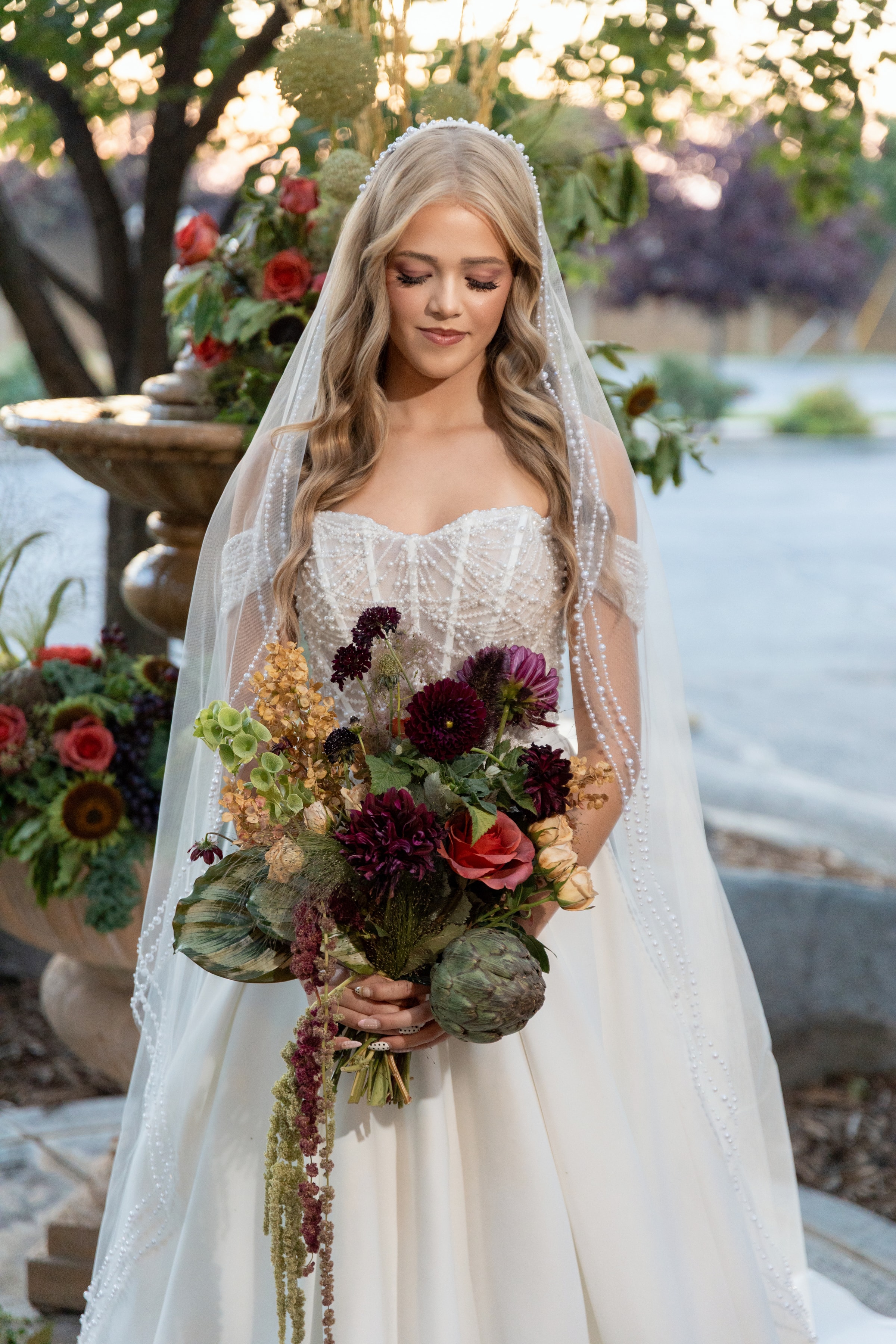 Cascading bridal bouquet with white roses and tropical greenery