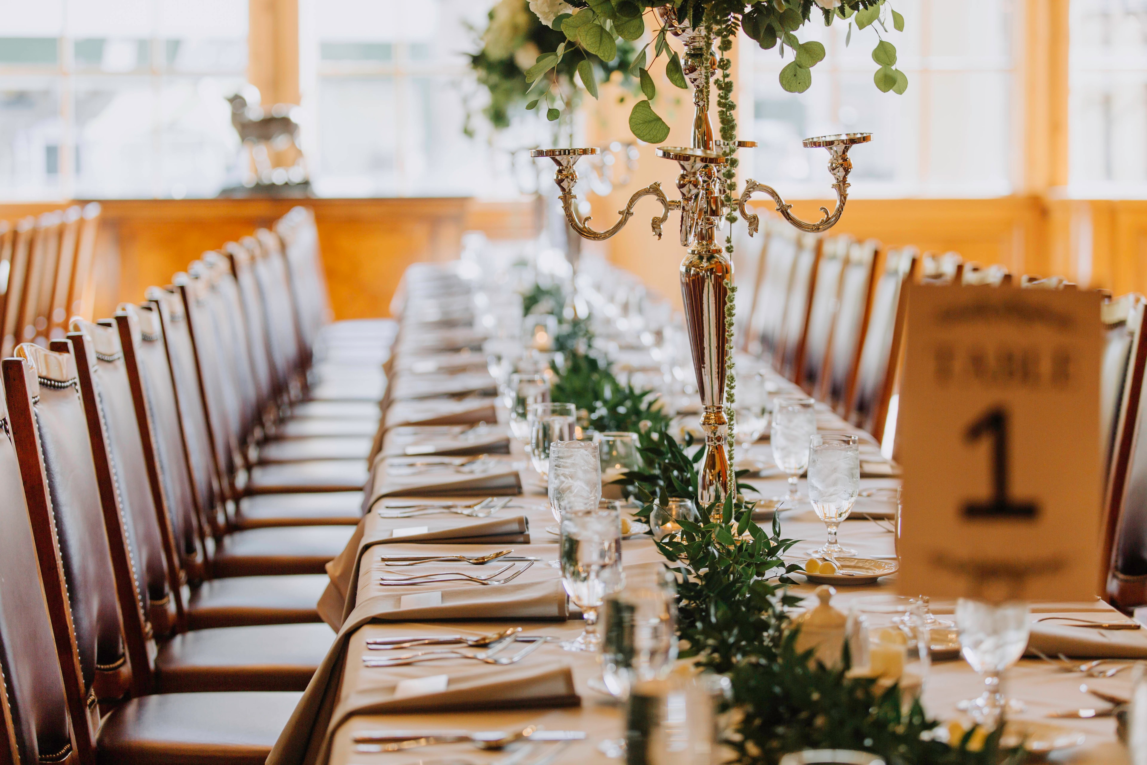 Long reception table with greenery garland and candelabra centerpieces